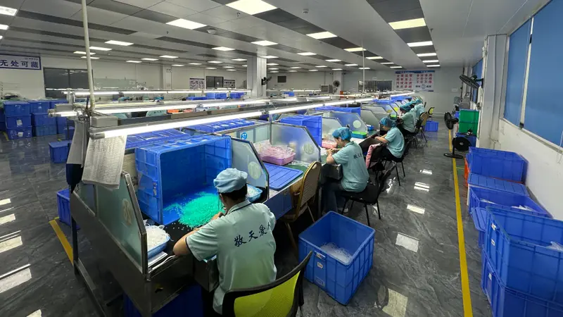 Operators working at illuminated manual finishing and visual-check stations